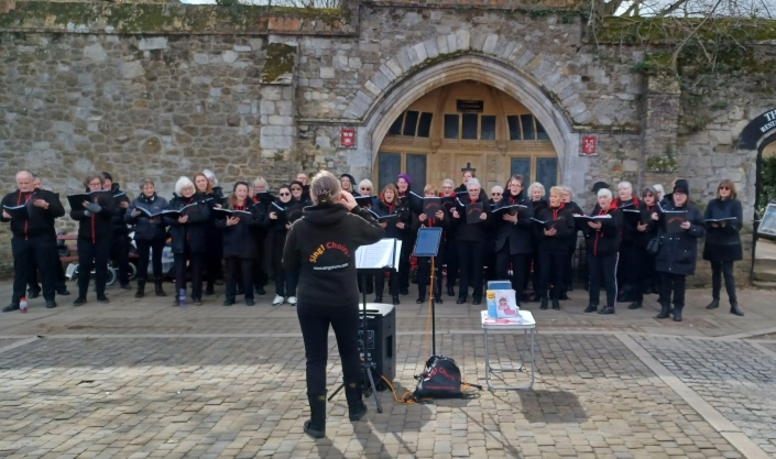 Sing! Choirs Singing on Ely Market in March 2022, next to the War Memorial where we will be for our first performance of 2023!